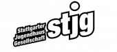stjg-Logo mit weißer Schrift und schwarzer Umrandung